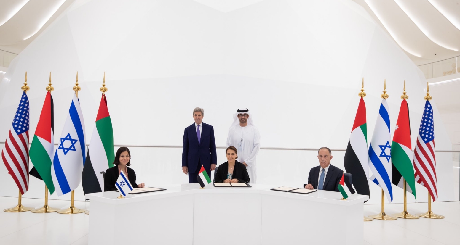 L-R: Energy and Water Resources Minister Karine Elharrar, UAE Climate Change Minister Mariam Almheiri and Jordan Water and Irrigation Minister Mohammed Al-Najjar sign a water agreement at a Dubai Expo event on November 22, 2021, as US Climate Envoy John Kerry and UAE Crown Prince Mohammed bin Zayed look on. (UAE Foreign Ministry/Twitter)